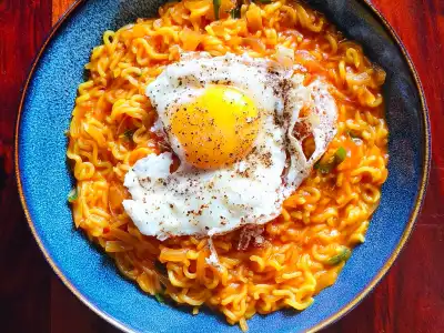 Bowl of spicy ramen noodles topped with a fried egg