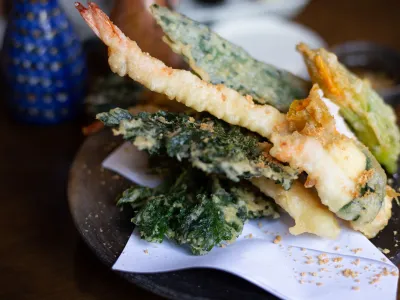 Crispy fried shrimp and vegetable tempura on a plate lined with paper