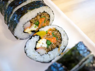 Close-up of thick gimbap rolls cut open to show rice, vegetables and a creamy filling